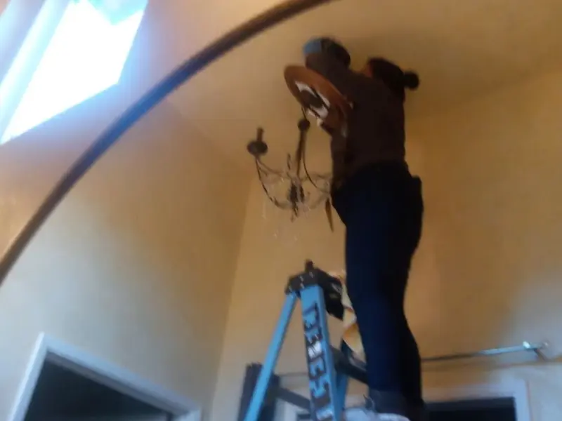 Electrician installing a chandelier in a West Columbia residence